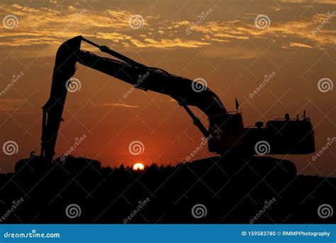 mini excavator sunset|Mini Excavator At Sunset Stock Photo .